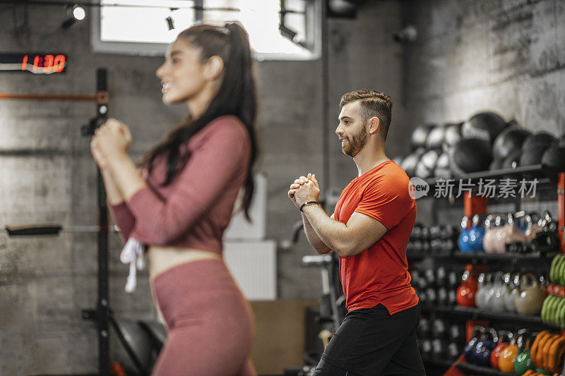 Young people doing lunges together during their workout in a gym